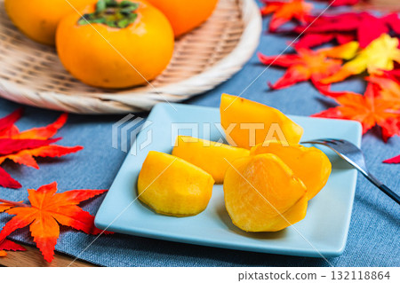 Seedless persimmons and autumn leaves 132118864