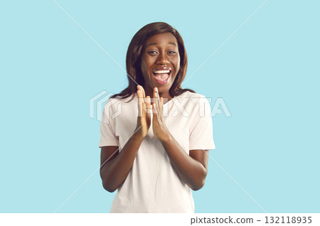 Happy woman clapping hands on isolated blue background and looking excited at the camera. Happy woman clapping hands on isolated blue background and looking excited at the camera. 132118935