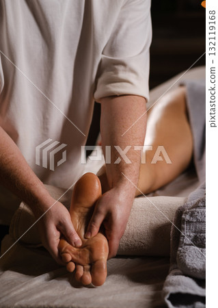 Relaxing foot massage therapy session in a calming spa environment during evening hours 132119168