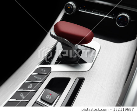 Automatic gear stick of a modern car. Modern car interior details. Close up view. Car inside. Automatic transmission lever shift. Black leather interior with stitching 132119697