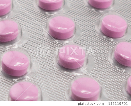 Macro shot pile of tablets pill in silver blister packaging isolated on white background. Aluminium foil blister pack. Pharmacy products. Medicine pills and drugs close up. Pills background Macro shot pile of tablets pill in silver blister packaging isolated on white background. Aluminium foil blister pack. Pharmacy products. Medicine pills and drugs close up. Pills background 132119701