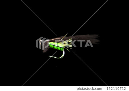Macro shot colorful fishing fly isolated on a black background. Hand made fly fishing flies. Fluffy fly fishing hook isolated. 132119712