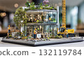 Miniature modern green building diorama with construction workers and eco-friendly landscaping 132119784