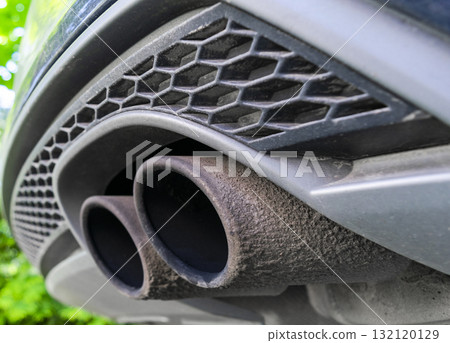 Close up of a car dual exhaust pipe. Double exhaust pipes of a modern sports car. Car exterior details. Close up of a car dual exhaust pipe. Double exhaust pipes of a modern sports car. Car exterior details. 132120129