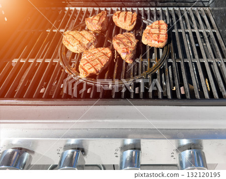 Beef fillet steak on the gas grill. Grilling of beef meat on outdoor gas grill. Grilled meat steak on stainless grill depot Beef fillet steak on the gas grill. Grilling of beef meat on outdoor gas grill. Grilled meat steak on stainless grill depot 132120195