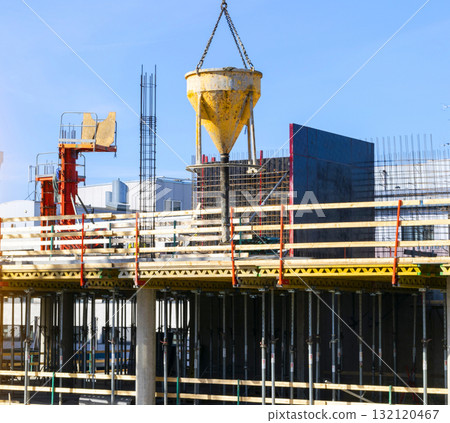 Construction crane tower on blue sky background. Crane and building working progress. Worker. Construction concept. New buildings with a crane. Tower crane 132120467