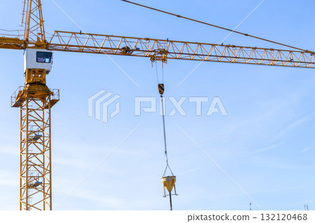 Construction crane tower on blue sky background. Crane and building working progress. Worker. Construction concept. New buildings with a crane. Tower crane 132120468