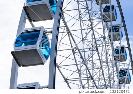 Ferris wheel in an amusement park with a blue sky background. City park ferris wheel in Carousel Gardens. Ferris wheel in an amusement park with a blue sky background. City park ferris wheel in Carousel Gardens. 132120471