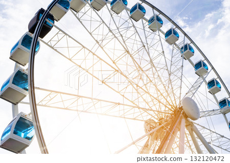 Ferris wheel in an amusement park with a blue sky background. City park ferris wheel in Carousel Gardens. Ferris wheel in an amusement park with a blue sky background. City park ferris wheel in Carousel Gardens. 132120472