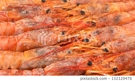 Raw frozen shrimp background. Pile of frozen shrimps. Close-up of frozen shrimps. A lot of royal shrimp macro shot. Red giant argentine shrimp texture background. Large tiger shrimp 132120478
