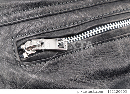 Macro shot of zipper on black leather texture background with stitching. Close-up of black leather material Macro shot of zipper on black leather texture background with stitching. Close-up of black leather material 132120603