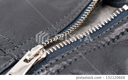 Macro shot of zipper on black leather texture background with stitching. Close-up of black leather material 132120608