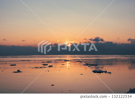 Sunrise over tranquil waters with ice floes reflecting soft light in an Arctic landscape Sunrise over tranquil waters with ice floes reflecting soft light in an Arctic landscape 132122534