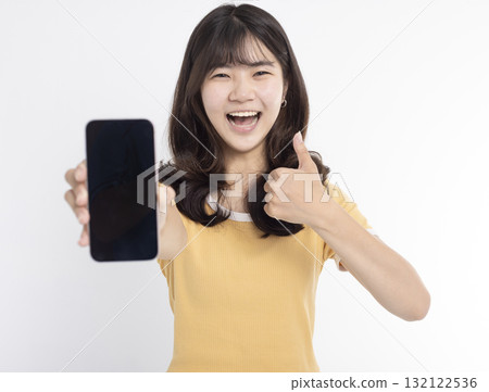 Asian girl showing or presenting mobile phone application and thumbs up isolated over white background Asian girl showing or presenting mobile phone application and thumbs up isolated over white background 132122536