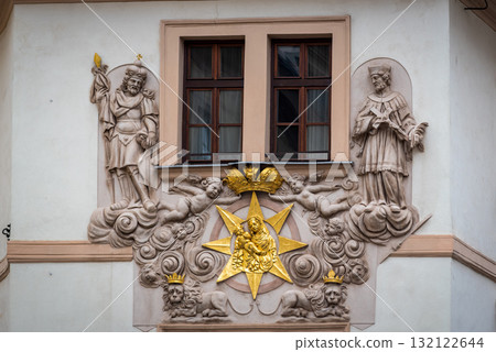 Ornate architectural facade with religious sculptures and golden star in Prague, Czech Republic 132122644