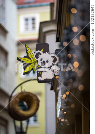 A whimsical koala sign with a cannabis leaf on a narrow street in Old town of Prague, Czech Republic 132122645