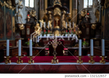 Ornate church altar with candles and cross, rich church decor in Prague, Czech Republic Ornate church altar with candles and cross, rich church decor in Prague, Czech Republic 132122657