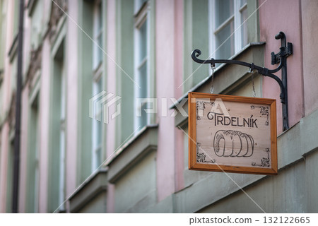 Wooden sign for a Trdelnik shop hanging on a facade in historic old town of Prague, Czech Republic Wooden sign for a Trdelnik shop hanging on a facade in historic old town of Prague, Czech Republic 132122665