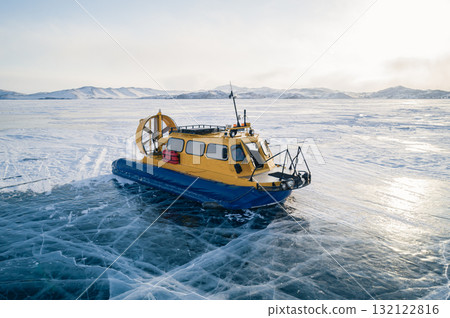 Aerial view on a hovercraft parked on the beautiful cracked ice of the lake Baikal. Winter Baikal, frozen lake. Amazing winter landscape. Aerial view on a hovercraft parked on the beautiful cracked ice of the lake Baikal. Winter Baikal, frozen lake. Amazing winter landscape. 132122816