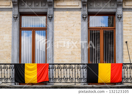 Belgian flags draped over the railing of decorative iron balcony in Brussels, Belgium 132123105
