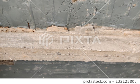 Close up of weathered wall with peeling paint and exposed wood showing signs of deterioration 132123803