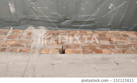 A low angle shot of a brick wall with gray tarp covering the top portion of the frame view 132123811
