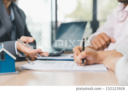 Close up of business people signing loan agreement contract with pen and paperwork on desk, financial deal concept with laptop and calculator in modern office environment. loan agreement contract. Close up of business people signing loan agreement contract with pen and paperwork on desk, financial deal concept with laptop and calculator in modern office environment. loan agreement contract. 132123926