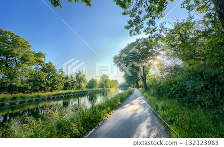 A Serene Pathway by the Water Under a Bright and Expansive Blue Sky on a Beautiful Day A Serene Pathway by the Water Under a Bright and Expansive Blue Sky on a Beautiful Day 132123983
