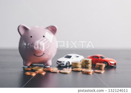 Pink piggy bank with stacked coins beside two car model, representing savings, car loan, finance, investment, wealth management, insurance and money planning on clean minimal background. Pink piggy bank with stacked coins beside two car model, representing savings, car loan, finance, investment, wealth management, insurance and money planning on clean minimal background. 132124011