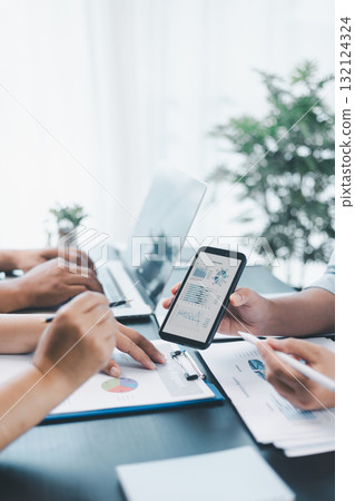 Business data analysis concept with colleagues reviewing financial report on smart phone, pointing at chart with growth graph, teamwork discussing statistics, planning strategy and corporate success. Business data analysis concept with colleagues reviewing financial report on smart phone, pointing at chart with growth graph, teamwork discussing statistics, planning strategy and corporate success. 132124324