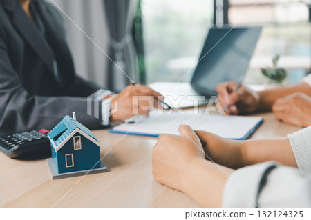 Close up of business people signing loan agreement contract with pen and paperwork on desk, financial deal concept with laptop and calculator in modern office environment. loan agreement contract. Close up of business people signing loan agreement contract with pen and paperwork on desk, financial deal concept with laptop and calculator in modern office environment. loan agreement contract. 132124325