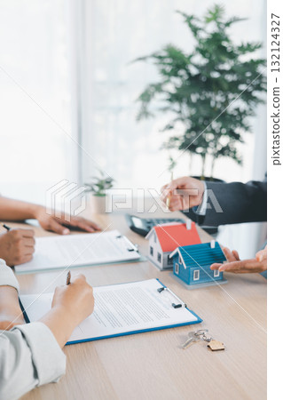 Close up of business people signing loan agreement contract with pen and paperwork on desk, financial deal concept with laptop and calculator in modern office environment. loan agreement contract. Close up of business people signing loan agreement contract with pen and paperwork on desk, financial deal concept with laptop and calculator in modern office environment. loan agreement contract. 132124327