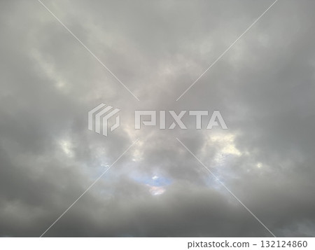 透過雲層的縫隙,可以看到晴朗的天空。 透過雲層的縫隙,可以看到晴朗的天空。 132124860