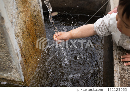 Child washing hands with water 132125963