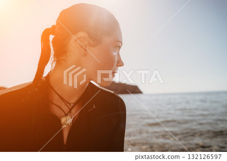 Woman Ocean Sunset Beach - A woman stands by the ocean, gazing out at the sunset. 132126597