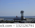 With a clear blue sky in the background, the Blue Impulse flies over the Marine Tower and a large passenger ship in Oarai, Ibaraki Prefecture, spewing smoke. 132126791