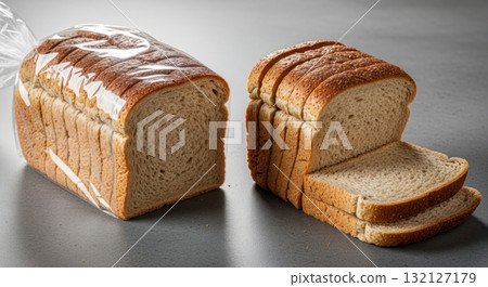 Fresh whole wheat sliced bread, one loaf packaged and another unwrapped on a table Fresh whole wheat sliced bread, one loaf packaged and another unwrapped on a table 132127179