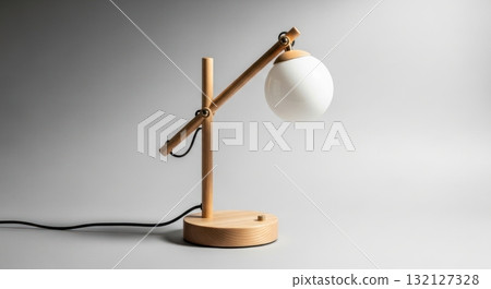 Minimalist wooden desk lamp with spherical white glass shade on a clean grey background 132127328