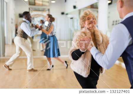 Mature woman learning to dance lindy hop with younger man Mature woman learning to dance lindy hop with younger man 132127401
