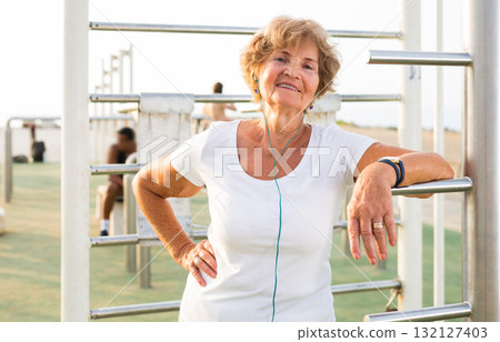 Mature sportswoman in workout station Mature sportswoman in workout station 132127403