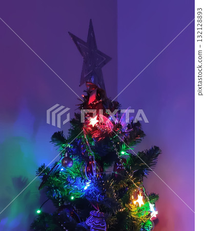 Close-up of decorated Christmas tree with glowing lights. Close-up of decorated Christmas tree with glowing lights. 132128893