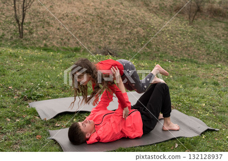 Joyful moments of playful fitness in nature with kids exercising together on mats, enjoying the outdoors during a sunny afternoon in springtime Joyful moments of playful fitness in nature with kids exercising together on mats, enjoying the outdoors during a sunny afternoon in springtime 132128937