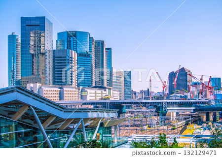 Tokyo cityscape in Japan. View of Shinagawa Station, office buildings, trains, etc. Takanawa Gateway Station is in the foreground. 132129471