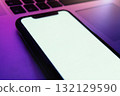 Mock up, modern smartphone with blank white screen lies on laptop 132129590