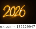 Glowing golden light painting of the number 2026 on a dark background 132129947
