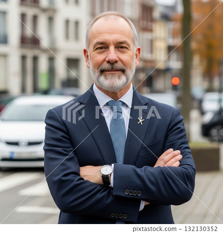 Confident mature caucasian businessman in a stylish suit and tie standing in a modern city 132130352