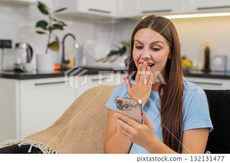 Young woman reads job offer on smartphone smiles covers mouth signs contract and sends accept reply 132131477