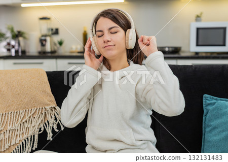 Young woman listens to music with wireless headphones relax rest calm chill break and recharge peace 132131483