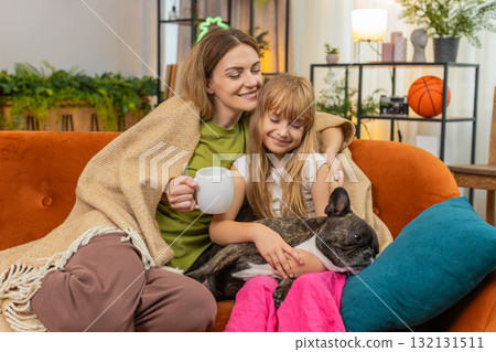 Mother daughter dog share tea and blanket relax together cozy rest hug smile comfort family evening Mother daughter dog share tea and blanket relax together cozy rest hug smile comfort family evening 132131511