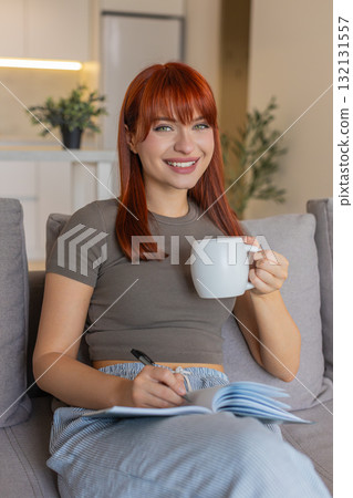 Young woman slowly drinks hot tea writes tomorrow task list in notebook relax and calm after stress 132131557